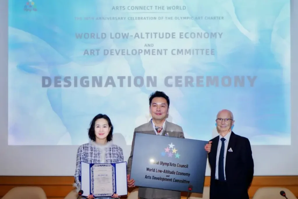 Crostars founder Shi Zheyuan receiving World Low-Altitude Economy and Arts Development Committee designation plaque at UNESCO Paris, July 2025 — World Olymp'Arts Council ceremony backdrop