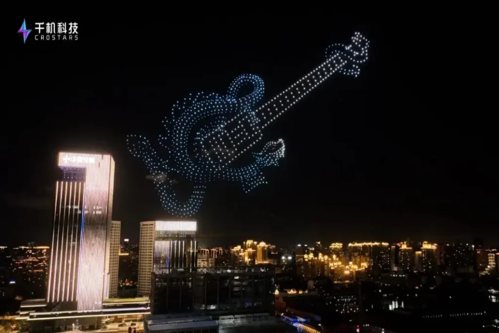 Crostars drone swarm forming Bahamut dragon guitar shape in night sky above Shanghai skyline during Wang Leehom concert warm-up show