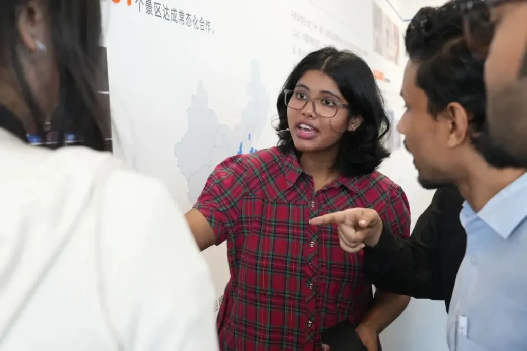 Bangladeshi trainee discussing Crostars drone show case studies during showroom tour at Shanghai headquarters, August 2025