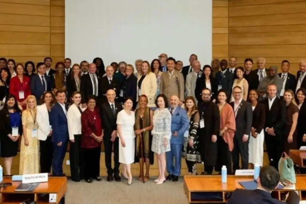 Group photo of 230+ delegates from 70+ countries at UNESCO headquarters Paris for the 30th Anniversary of the Olympic Art Charter, July 2025 — country name plates visible including Germany, Algeria, South Africa