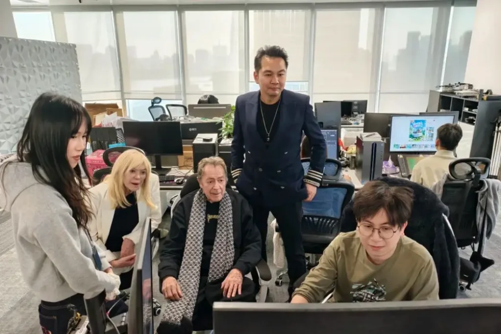 Charles Billich watching Crostars animator demonstrate drone light show design process at Shanghai design studio, with Chairman Shi Zheyuan looking on
