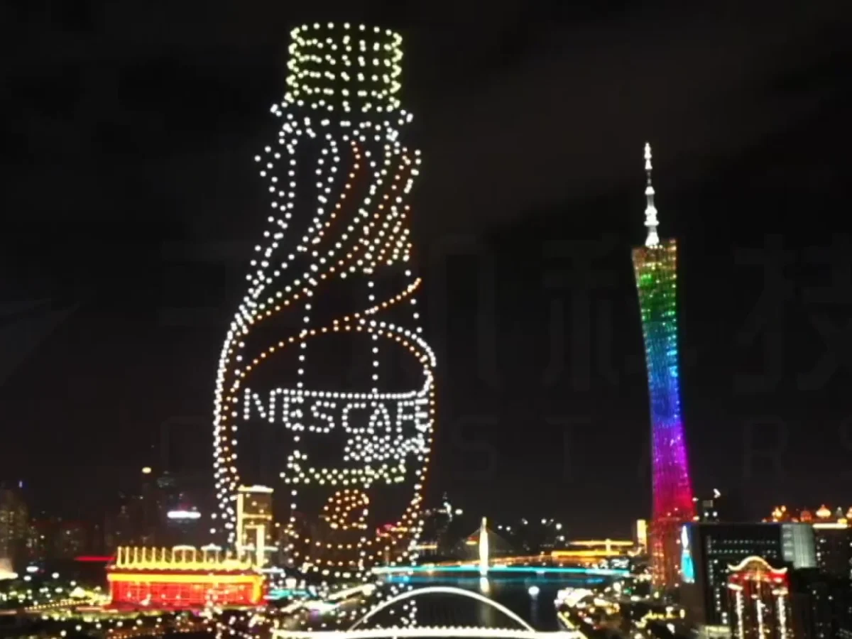 Crostars drones forming Nescafe coffee bottle above Guangzhou skyline with Canton Tower, 2023