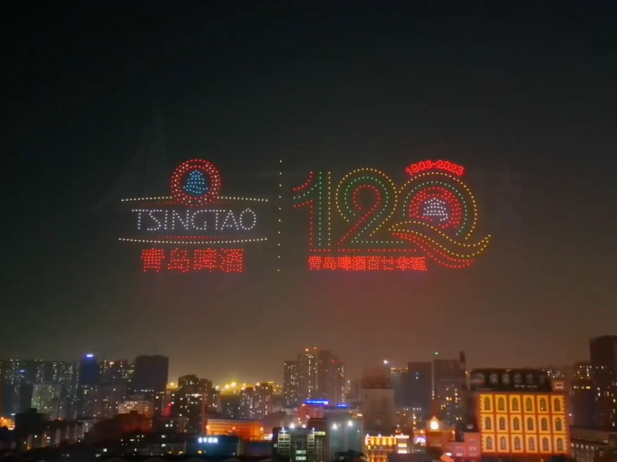 Crostars drones forming Tsingtao logo and 120 anniversary number above Qingdao skyline, 2023